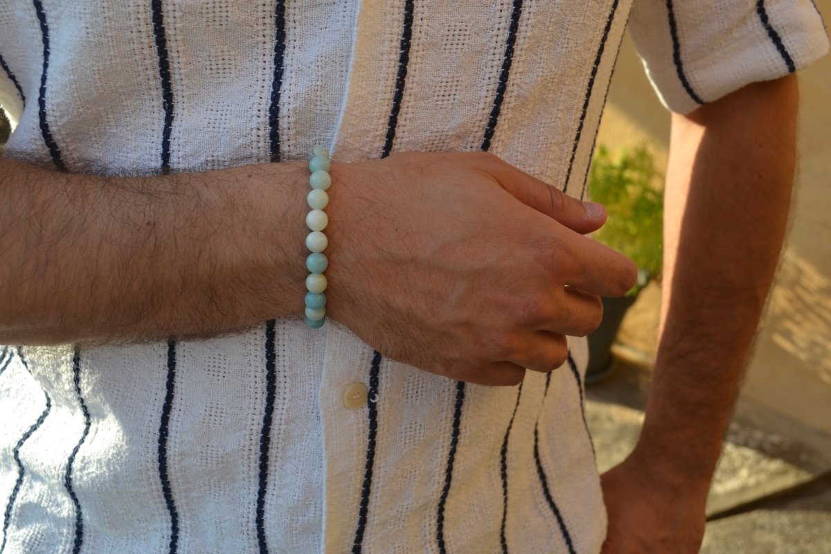 Bracelet Amazonite en pierre naturelle porté sur un poignet d'un homme au niveau du ventre. perle de diamètre 7-8mm