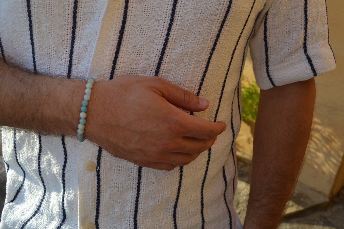 Bracelet Amazonite en pierre naturelle porté sur un poignet d'un homme au niveau du ventre. perle de diamètre 5-6mm