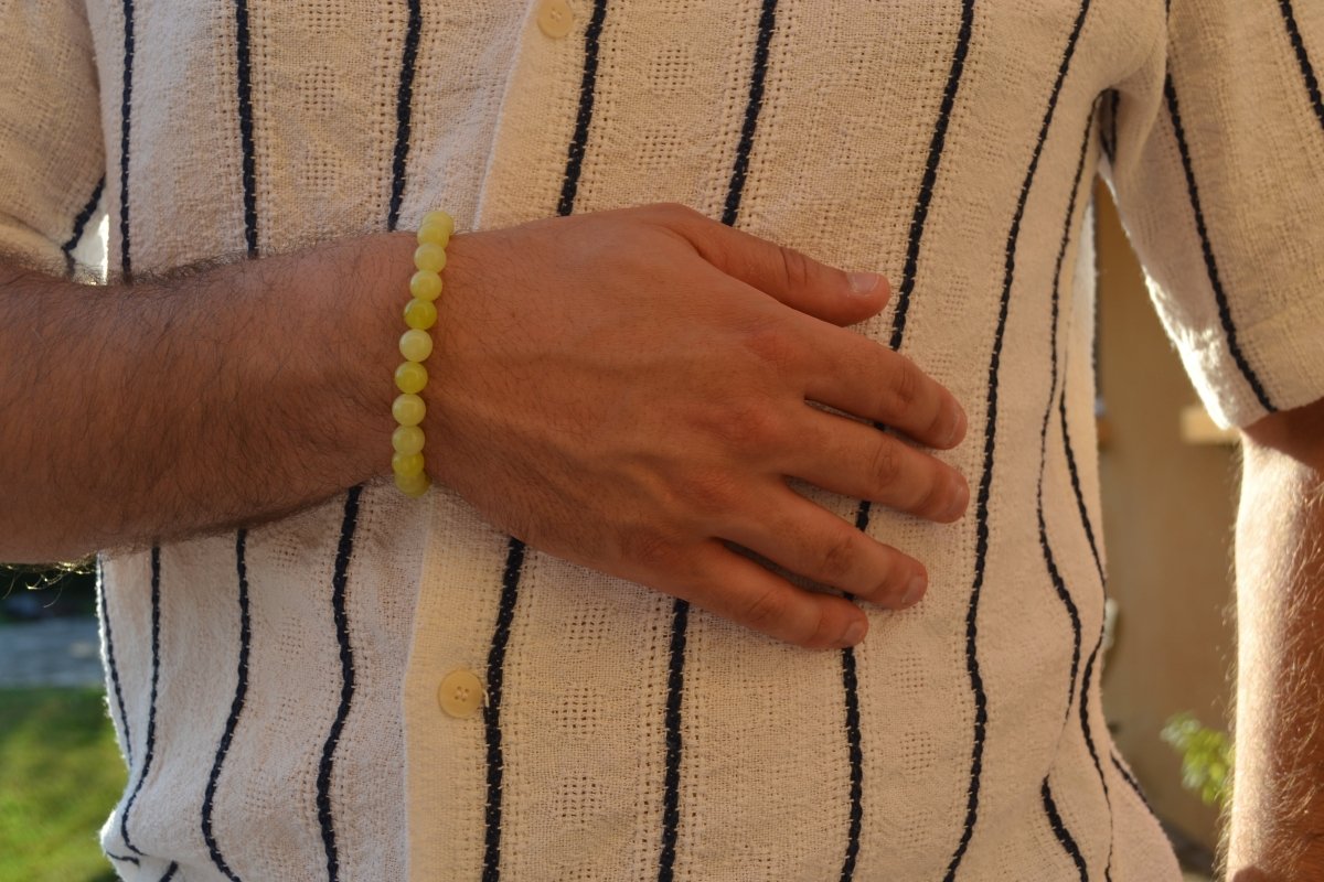 Bracelet Jade Citron en pierre naturelle porté sur un poignet d'un homme au niveau du ventre. perle de diamètre 7-8mm