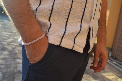 Bracelet Quartz Rose en pierre naturelle porté sur un poignet d'un homme au niveau de la hanche. perle de diamètre 7-8mm